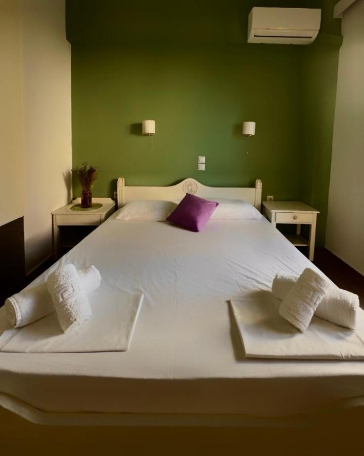 een slaapkamer met een groot wit bed met paarse kussens bij Almyra Apartments & Suites in Sfakaki +130 foto's