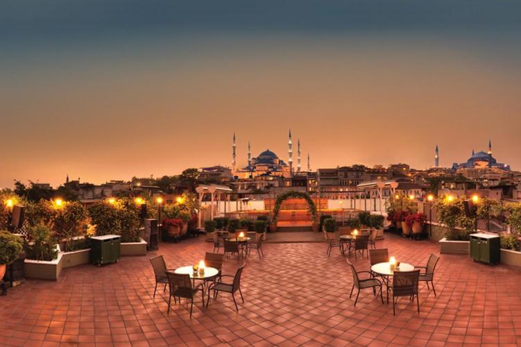 een terras met tafels en stoelen en een stad 's nachts bij Armada Istanbul Old City Hotel in Istanbul