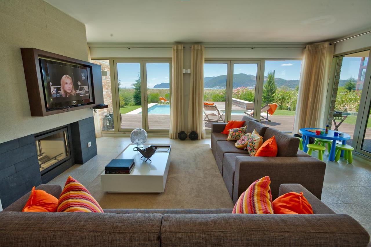 een woonkamer met twee banken en een tv bij Troia Residences - Apartamentos Praia in Troia