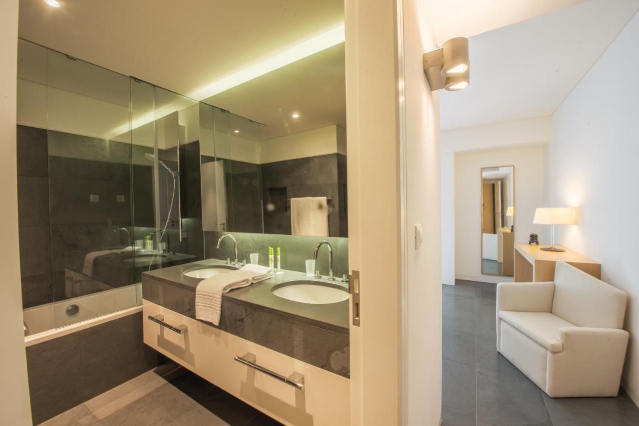 een badkamer met een wastafel en een glazen douche bij Troia Residences - Apartamentos Ácala in Troia +20 foto's
