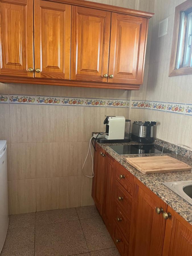een keuken met houten kasten en een aanrechtblad bij Yumbo Appartamenti Las Camelias Playa del Inglés in Playa del Inglé
