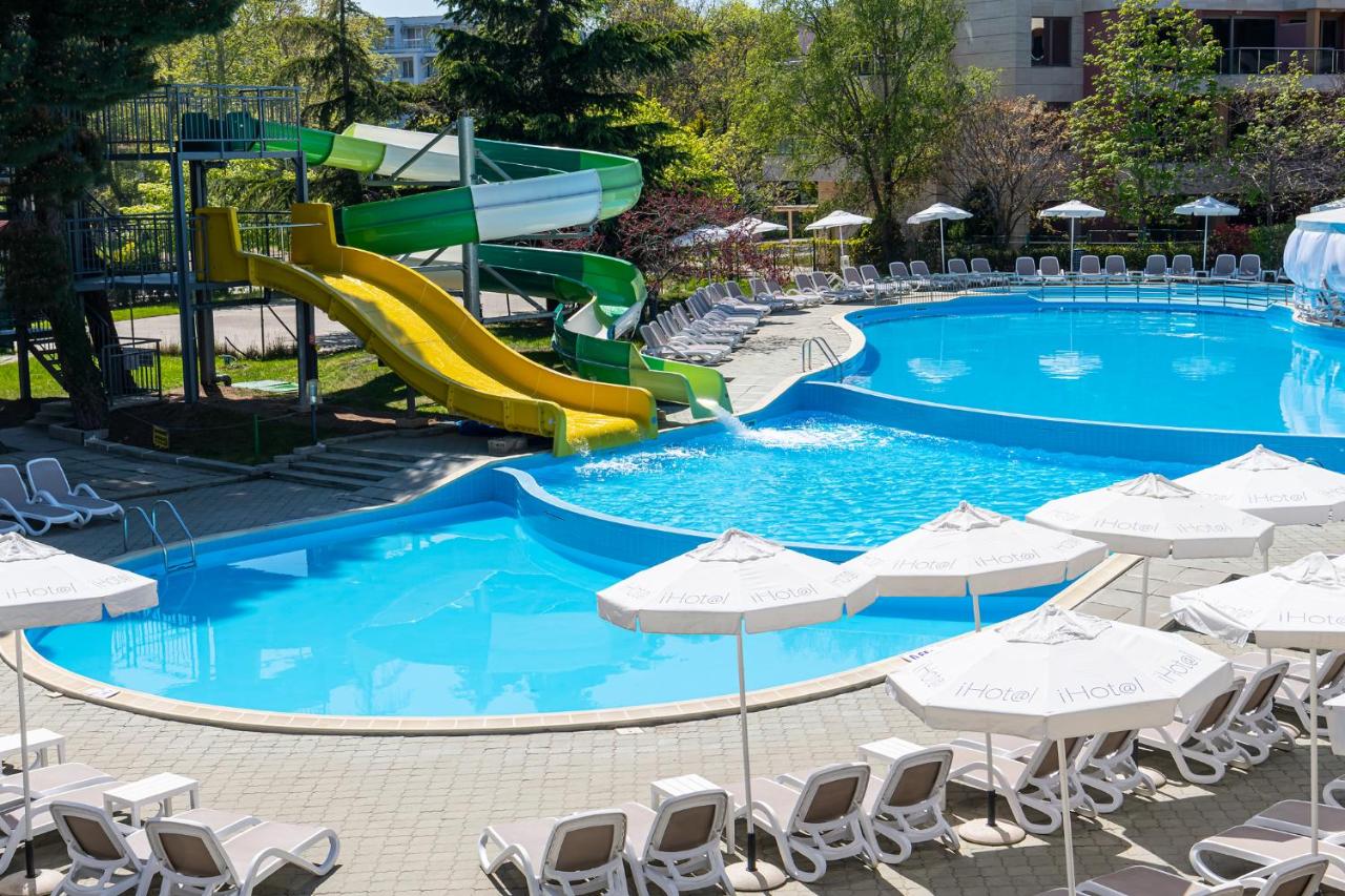 een zwembad met een glijbaan in een resort bij iHotel Sunny Beach in Sunny Beach