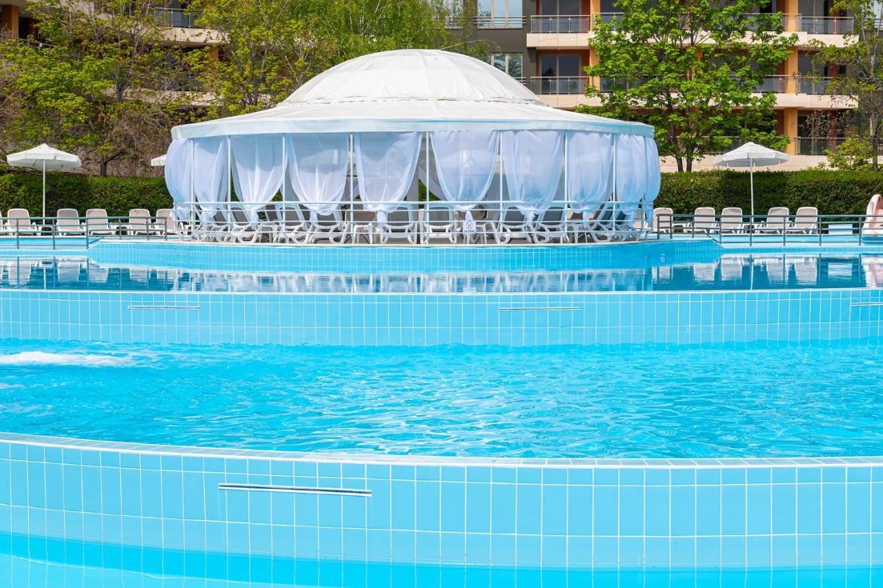 een zwembad met een tent, stoelen en water bij iHotel Sunny Beach in Sunny Beach