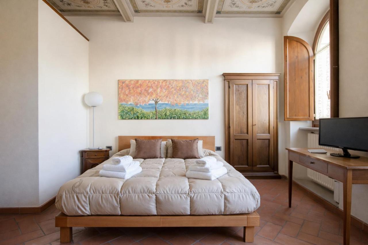 een slaapkamer met een bed, een bureau en een televisie bij La Corte Del Re Suite & Rooms Arezzo in Arezzo