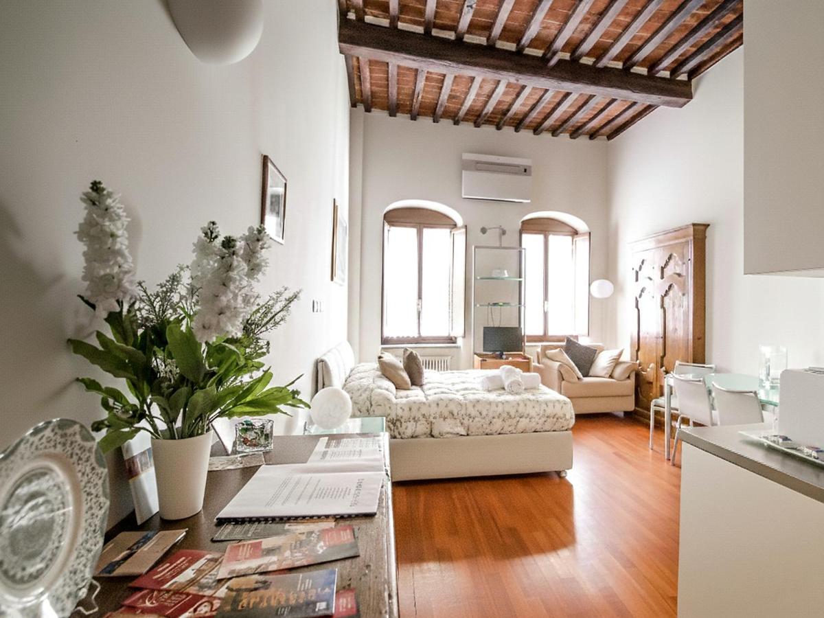 een woonkamer met een bed en een tafel bij La Corte Del Re Suite & Rooms Arezzo in Arezzo