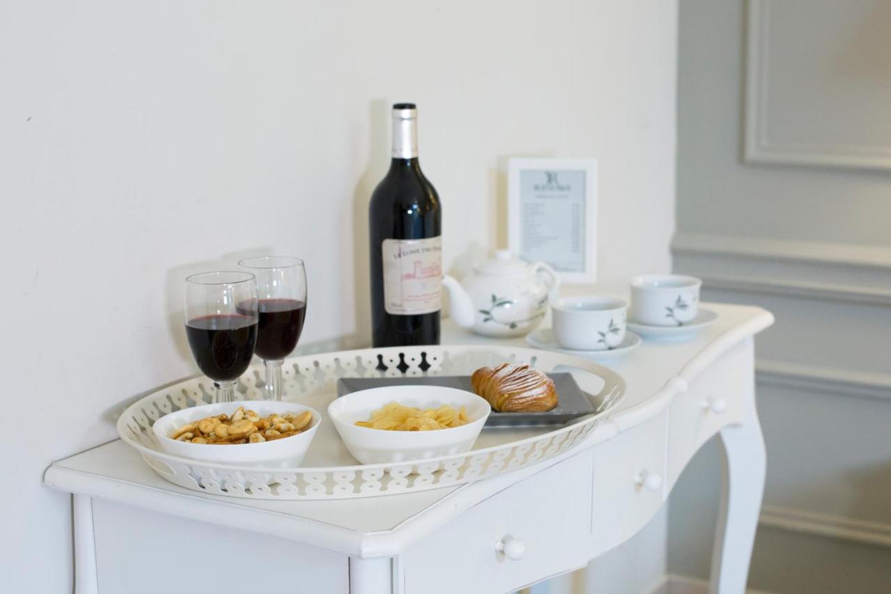 een witte tafel met een fles wijn en wijnglazen bij Ruins B&B in Ercolano