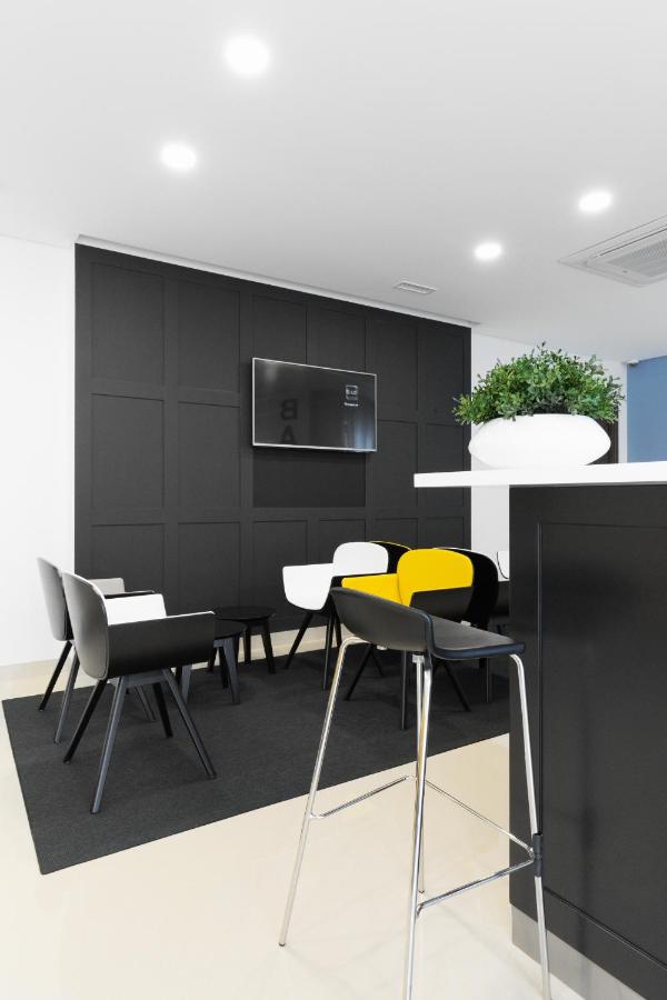 een kamer met stoelen, een tafel en een tv bij Fenicius Charme Hotel in Lissabon