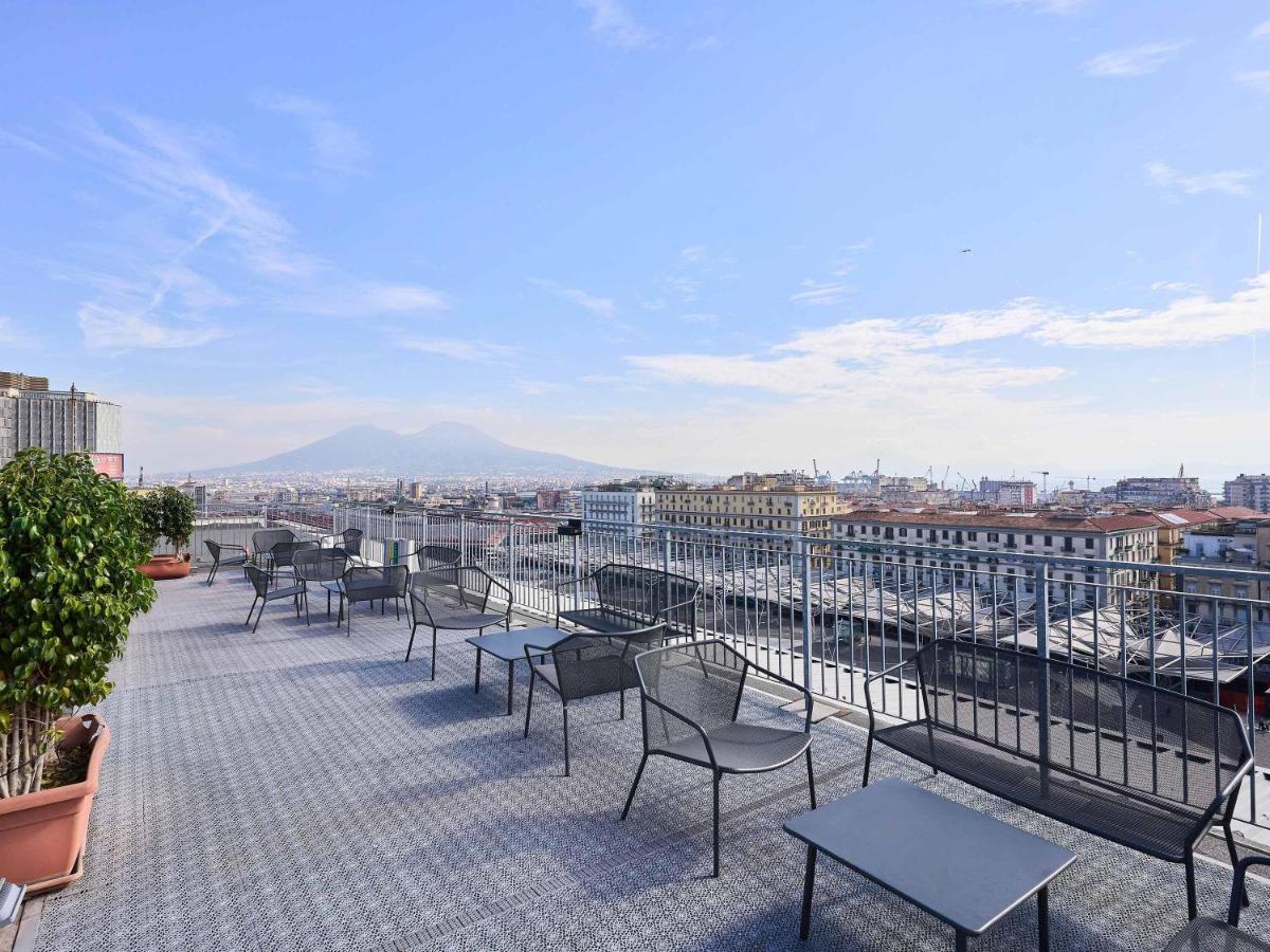 een balkon met stoelen en tafels op een gebouw bij B&B Hotel Napoli in Napels
