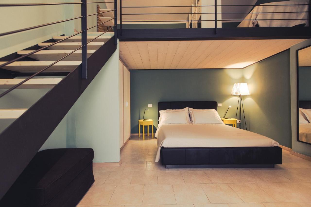 een slaapkamer met een groot bed en een trap bij Country Resort Le Due Ruote in Alberese +106 foto's