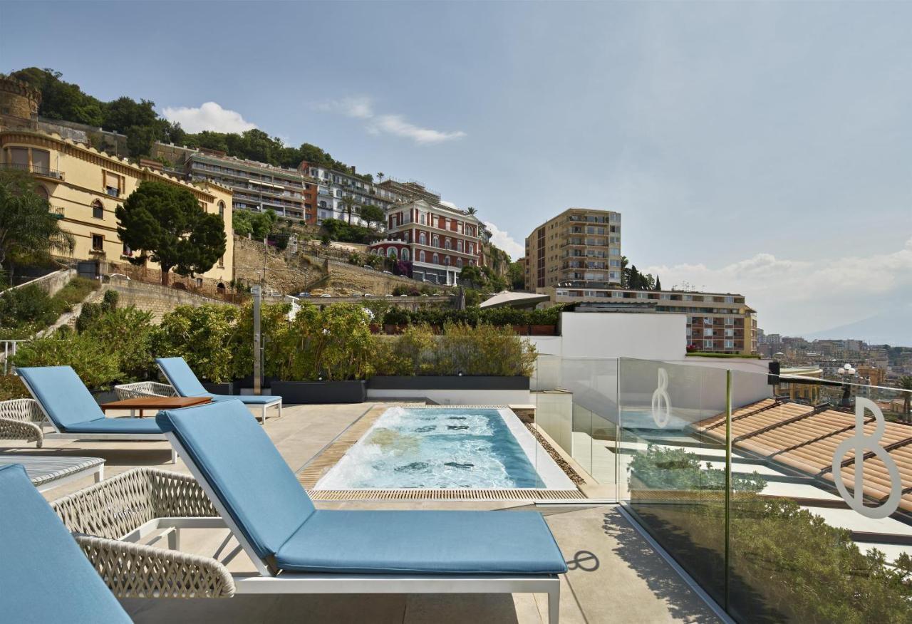 een terras met stoelen en een zwembad bovenop een gebouw bij De Bonart Naples, Curio Collection By Hilton in Napels