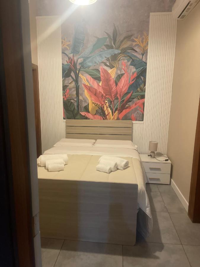 een slaapkamer met twee bedden en een schilderij aan de muur bij B&B Chez Moi in Napels