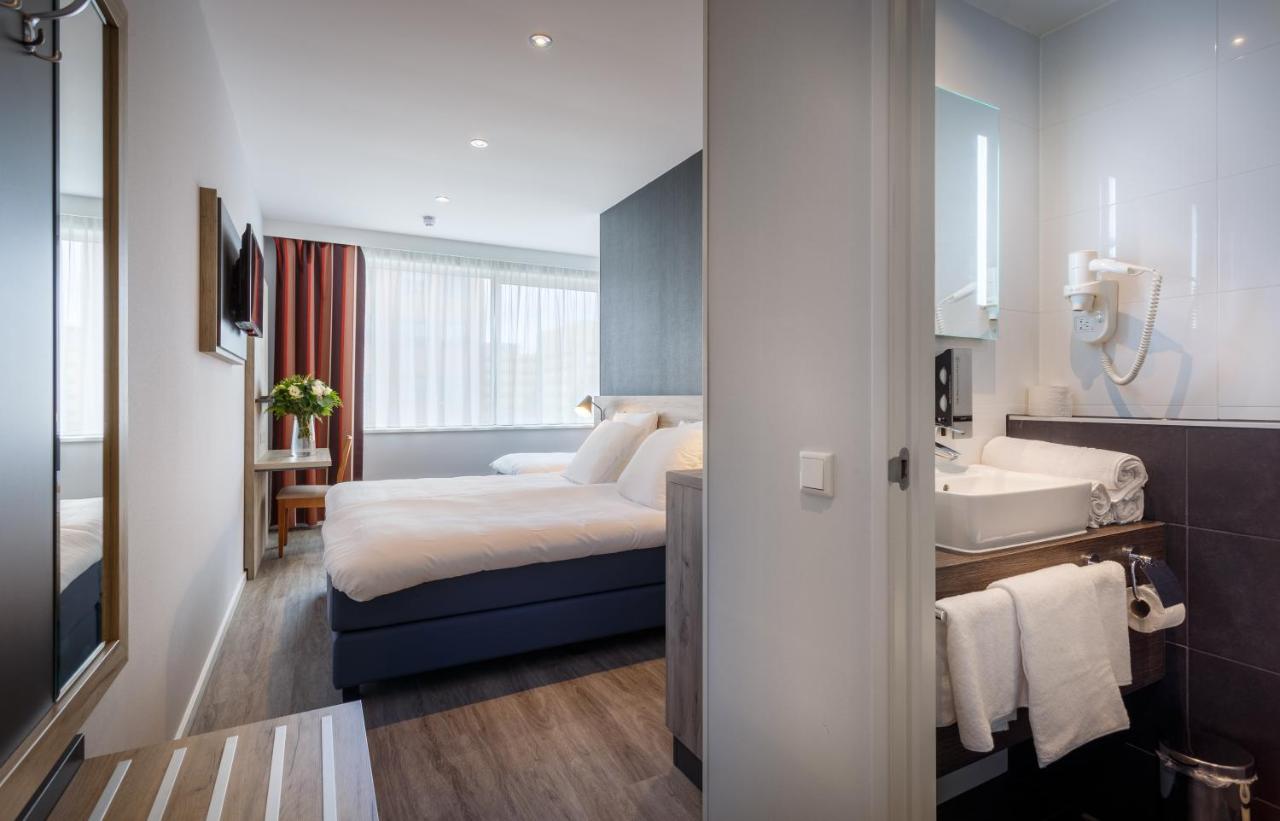 een hotelkamer met een bed en een wastafel bij Joy Hotel in Amsterdam