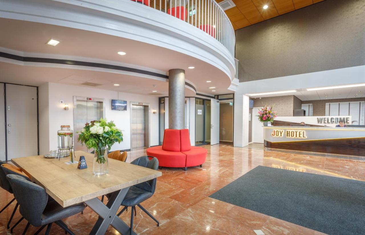 een eetkamer met een tafel en een rode stoel bij Joy Hotel in Amsterdam