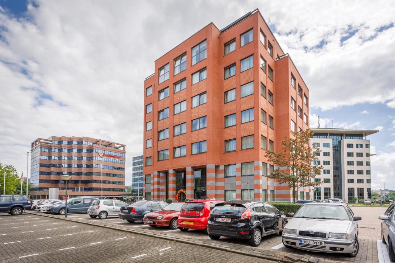 een parkeerplaats met auto's geparkeerd voor een gebouw bij Joy Hotel in Amsterdam