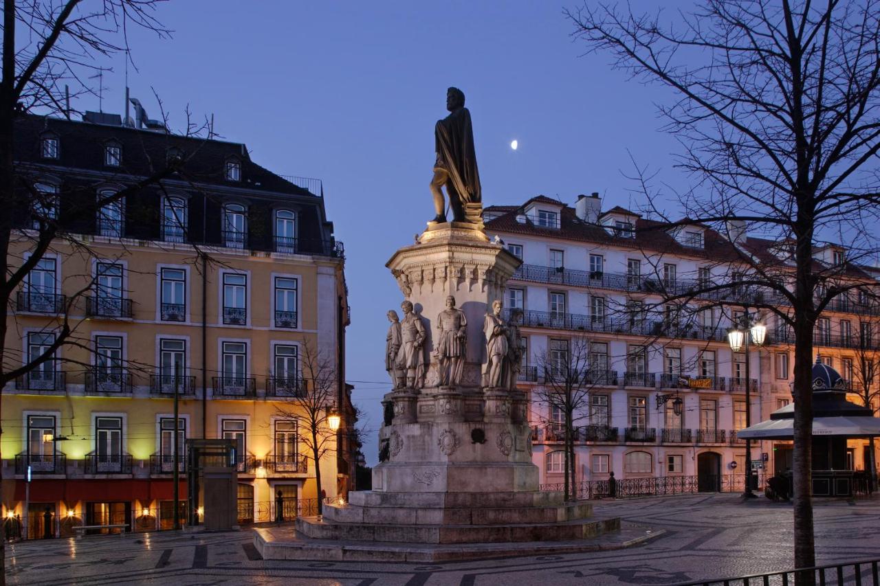 een standbeeld op een plein voor een gebouw bij Hotel Principe Real in Lissabon