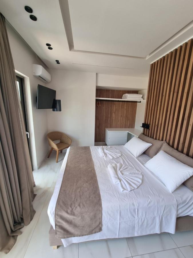 een slaapkamer met een groot bed met witte lakens bij Leonidas Studios & Apartments in Georgioupolis