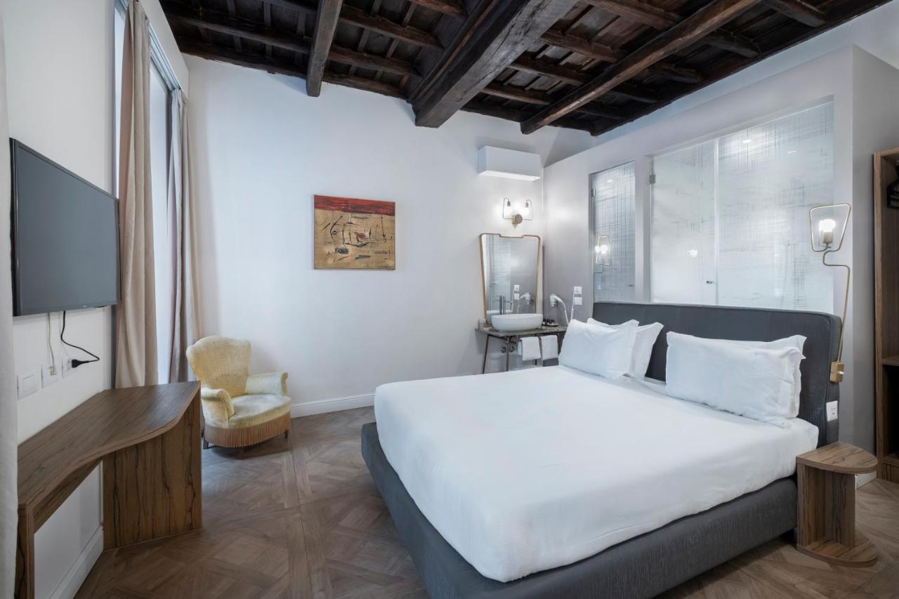 een slaapkamer met een groot wit bed en een tv bij 59 Steps Trevi in Rome