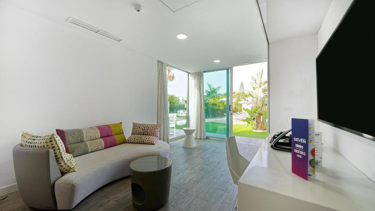 een woonkamer met een bank en een flatscreen-tv bij Seven Hotel & Wellness - Gay Men Only in Maspalomas