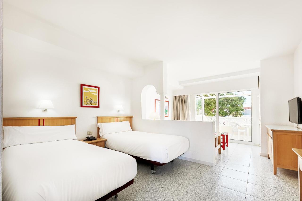 een hotelkamer met twee bedden en een tv bij Apartamentos LIVVO Koala Garden in Maspalomas