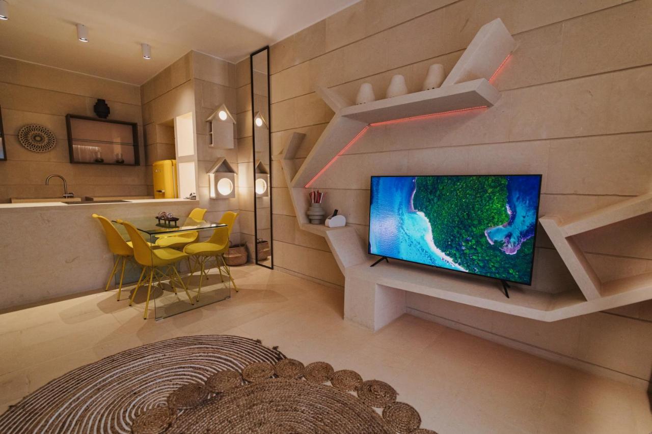 een woonkamer met een tv aan de muur bij Euphoria Resort in Olgiata +62 foto's