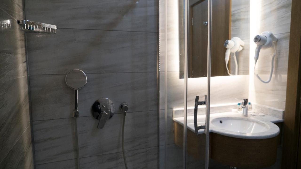 een badkamer met een douche, een wastafel en een spiegel bij Yuksel Istanbul Yenikapı Hotel in Istanbul