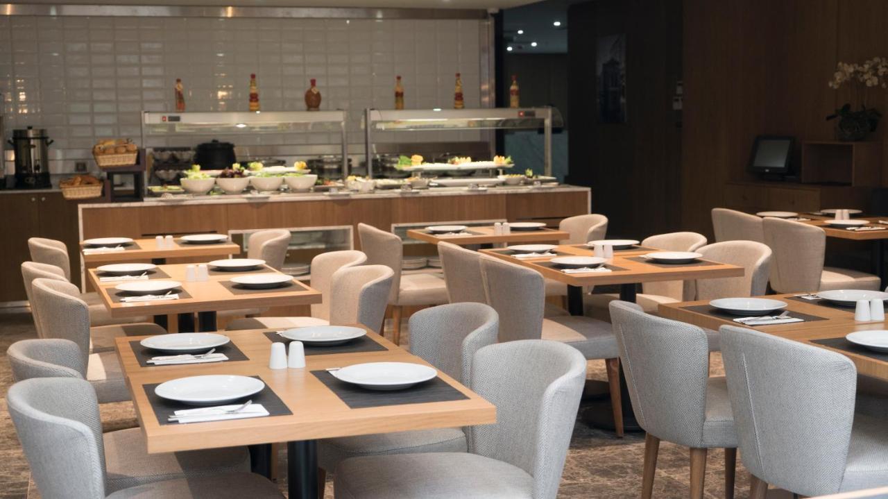 een restaurant met houten tafels en stoelen en een buffet bij Yuksel Istanbul Yenikapı Hotel in Istanbul