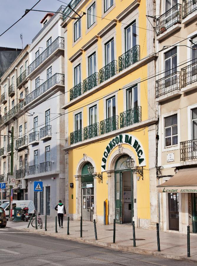 een geel gebouw met een uithangbord erop in een straat bij Lisbon Five Stars Apartments Bica in Lissabon