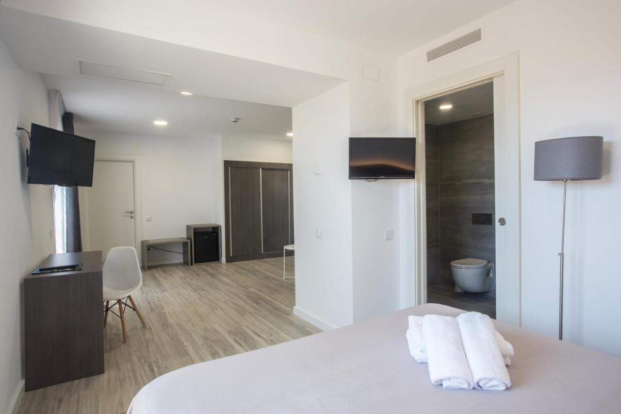 een hotelkamer met een bed, een bureau en een televisie bij Ona Don Juan in Lloret de Mar