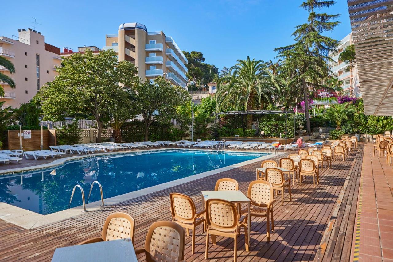 een rij tafels en stoelen naast een zwembad bij Ona Don Juan in Lloret de Mar