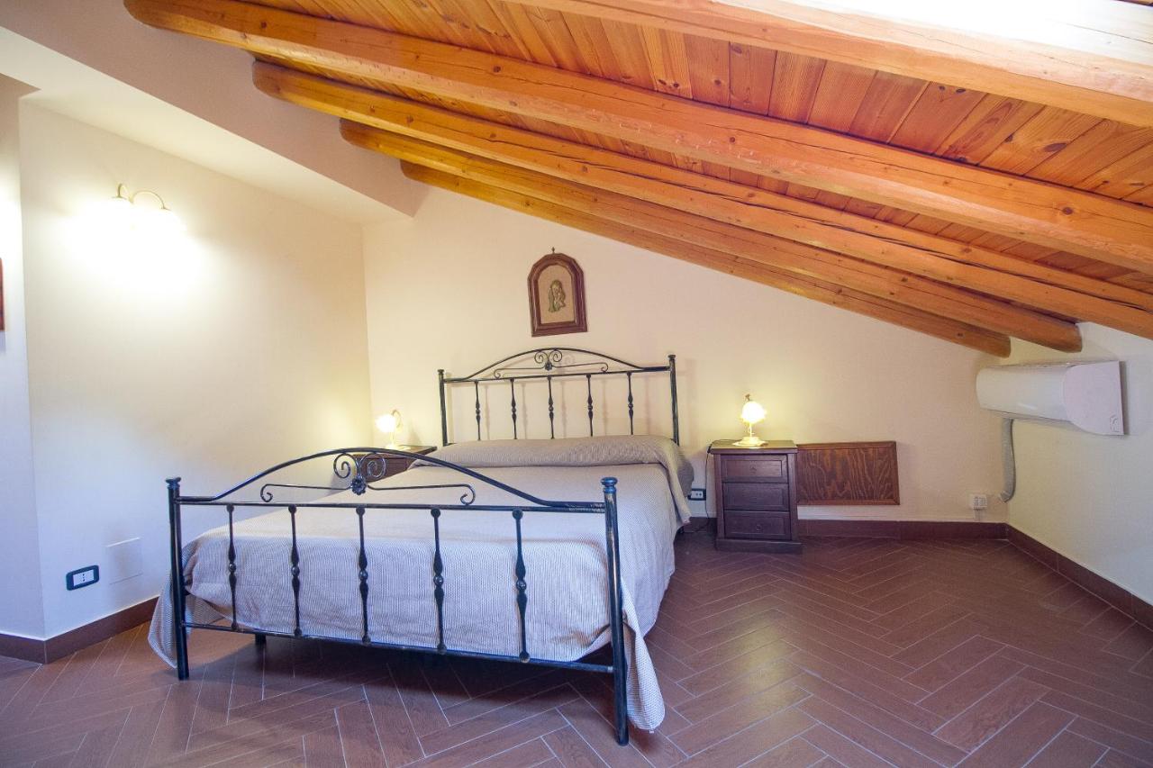 een slaapkamer met een bed en een houten plafond bij Etna Villa il Pino in Trecastagni