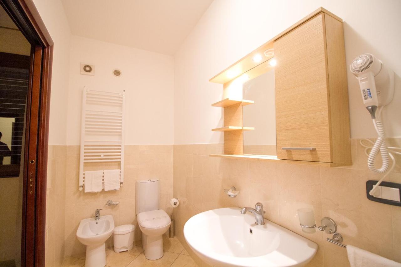 een badkamer met een wastafel, een toilet en een spiegel bij Etna Villa il Pino in Trecastagni