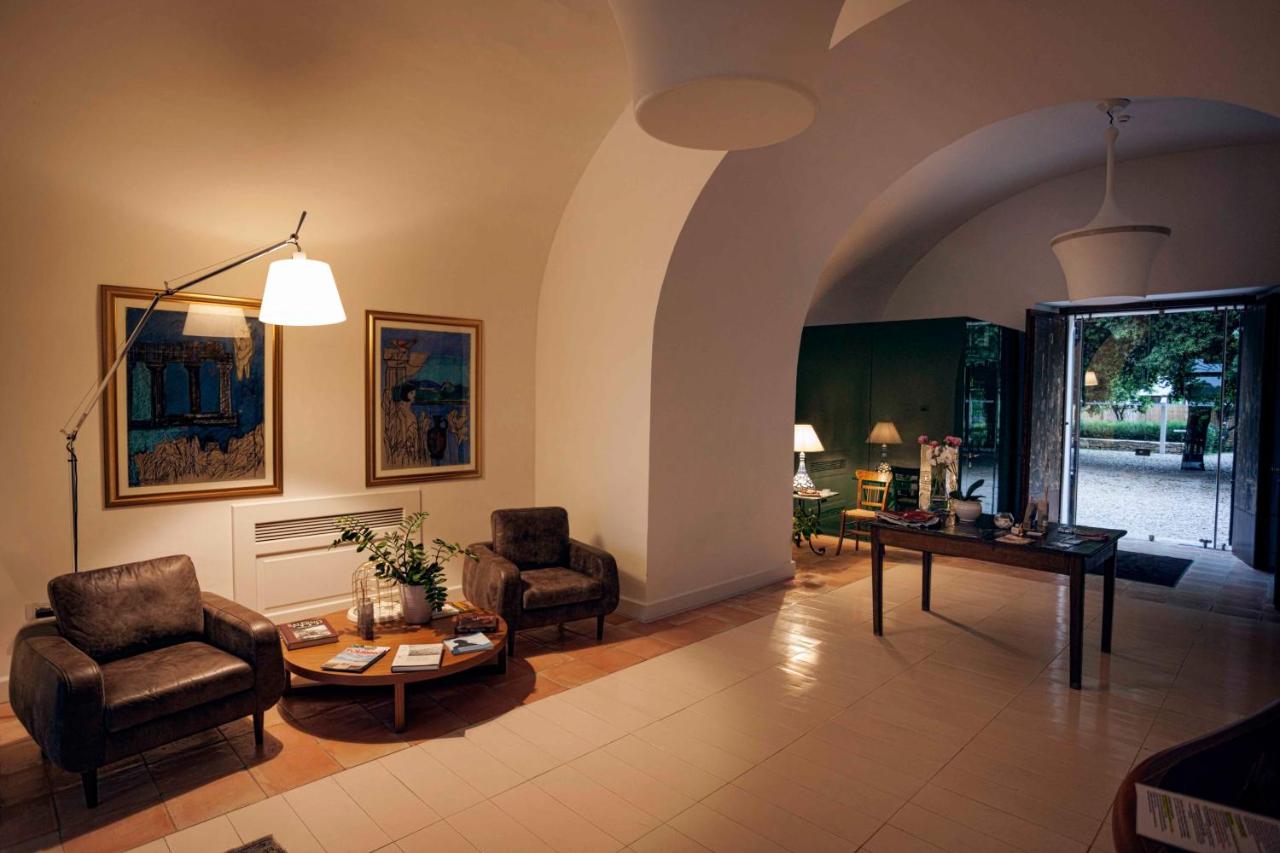 een woonkamer met twee stoelen en een tafel bij Tenuta Duca Marigliano Boutique Hotel in Paestum