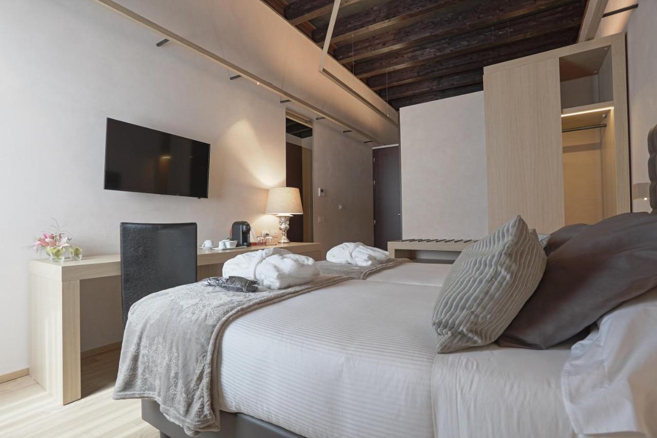 een slaapkamer met een wit bed en een tv aan de muur bij Alba Palace Hotel in Favara