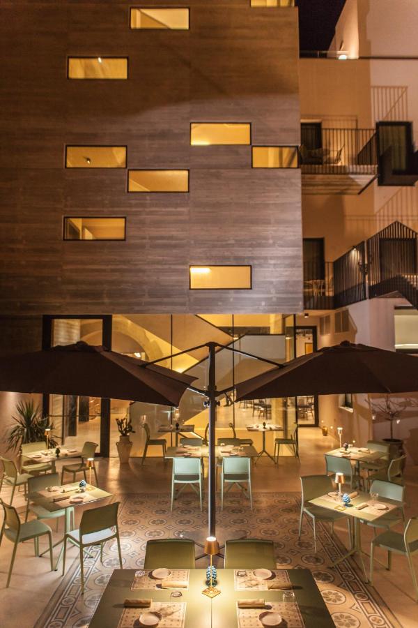 een restaurant met tafels en parasols voor een gebouw bij Alba Palace Hotel in Favara