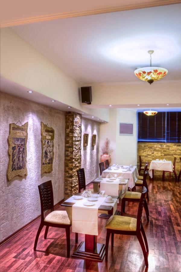 een restaurant met tafels en stoelen in een ruimte bij Nicola Hotel in Athene