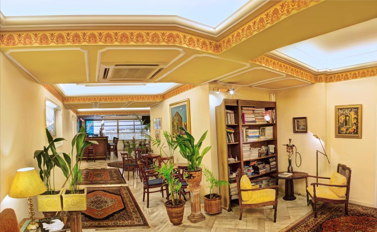 een woonkamer vol meubels en planten bij Nicola Hotel in Athene