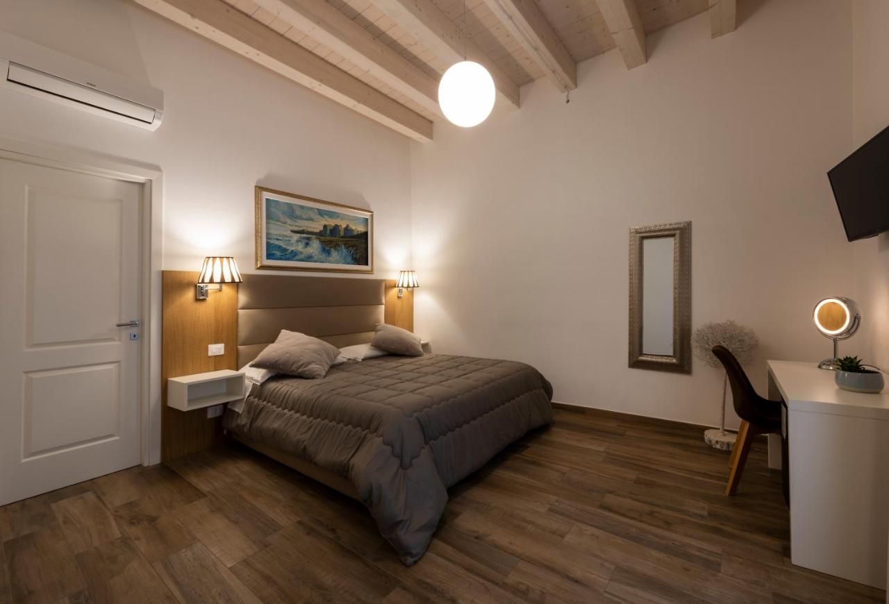 een slaapkamer met een bed, een tafel en een bureau bij B&B Palazzo San Michele in Bari