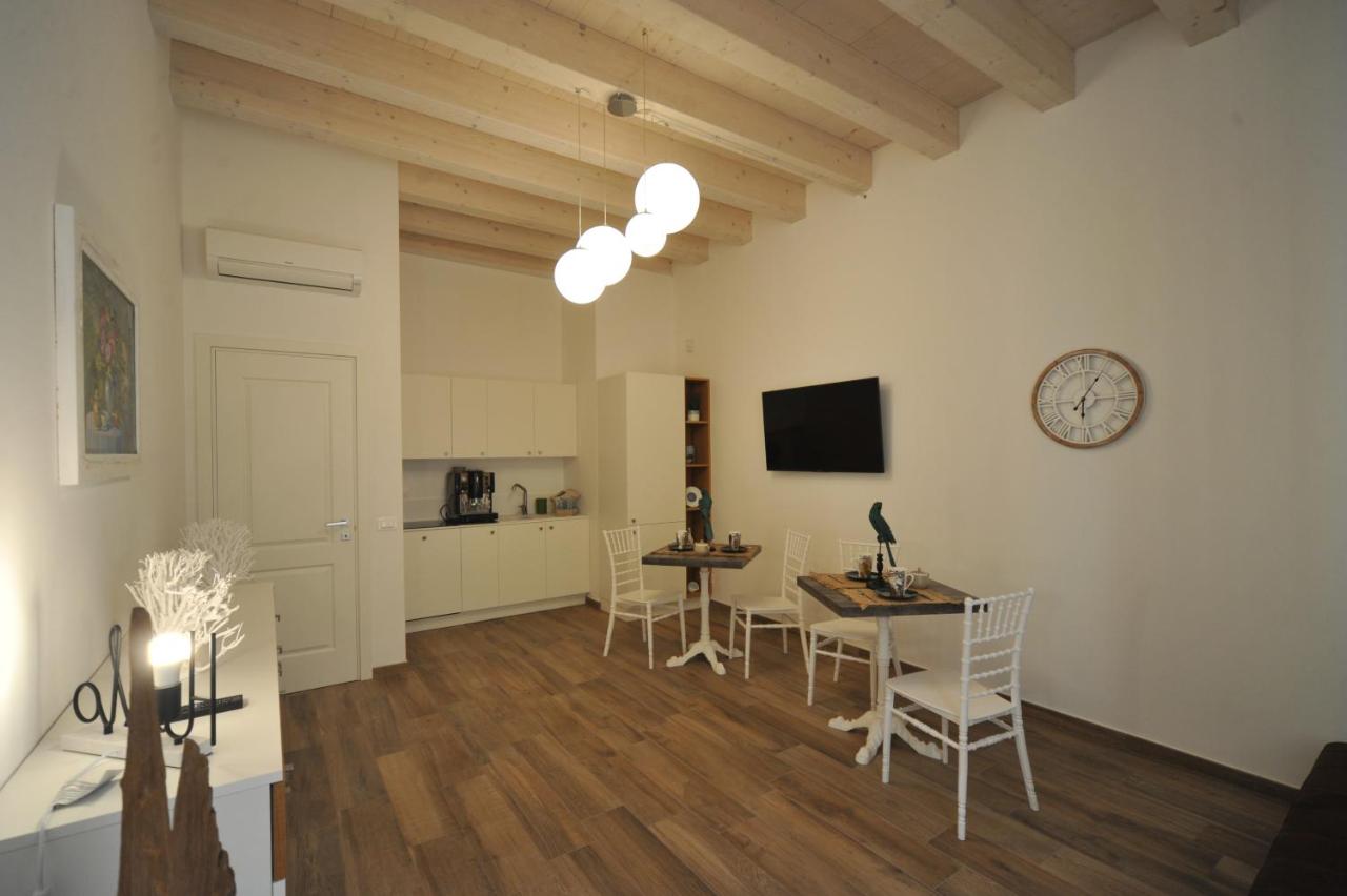 een woonkamer met een tafel en stoelen en een klok bij B&B Palazzo San Michele in Bari