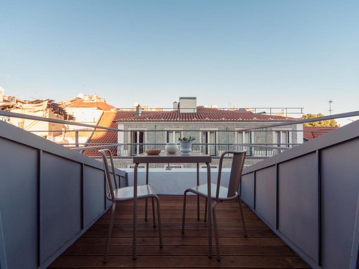 een balkon met een tafel en stoelen op een dak bij Dear Lisbon - Gallery House in Lissabon