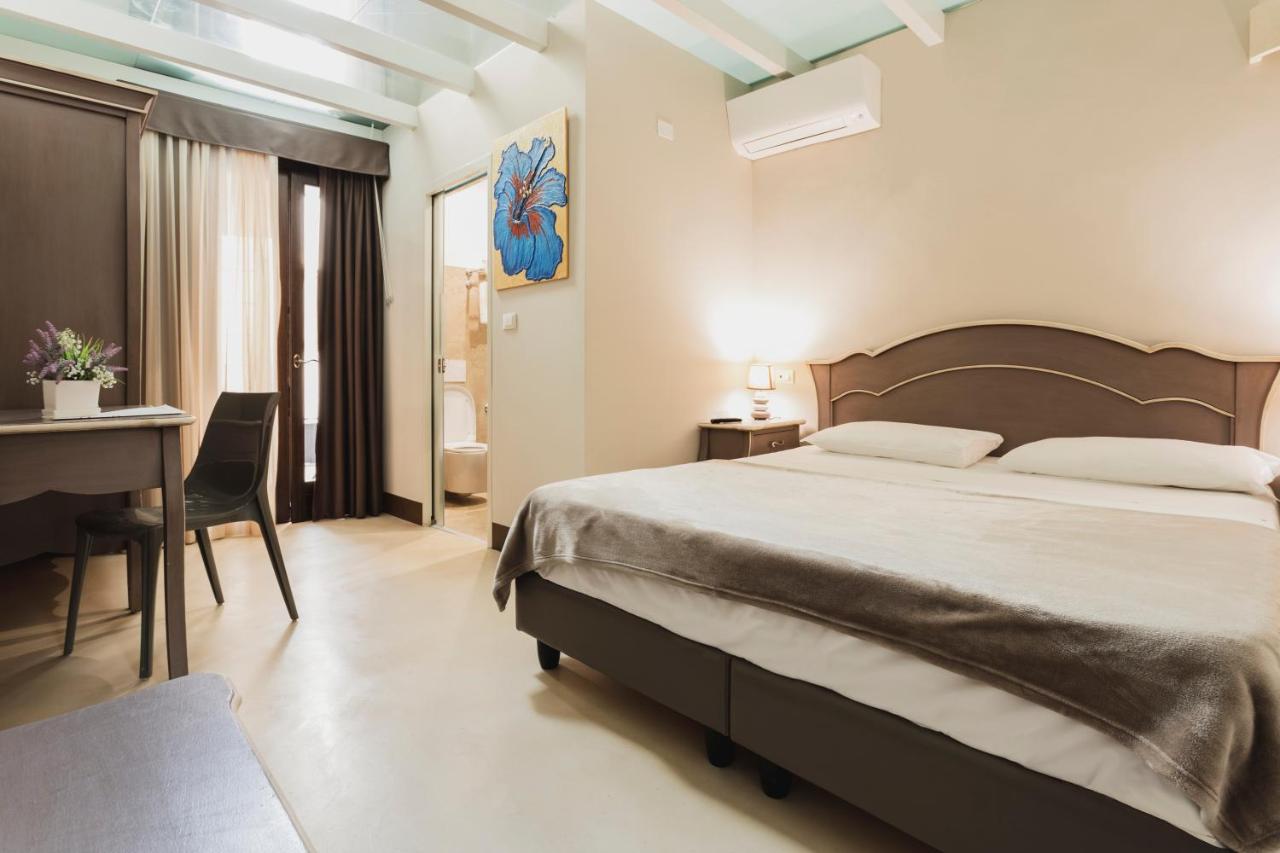 een slaapkamer met een bed, een tafel en een bureau bij Suite Porta Terra in Gallipoli +9 foto's