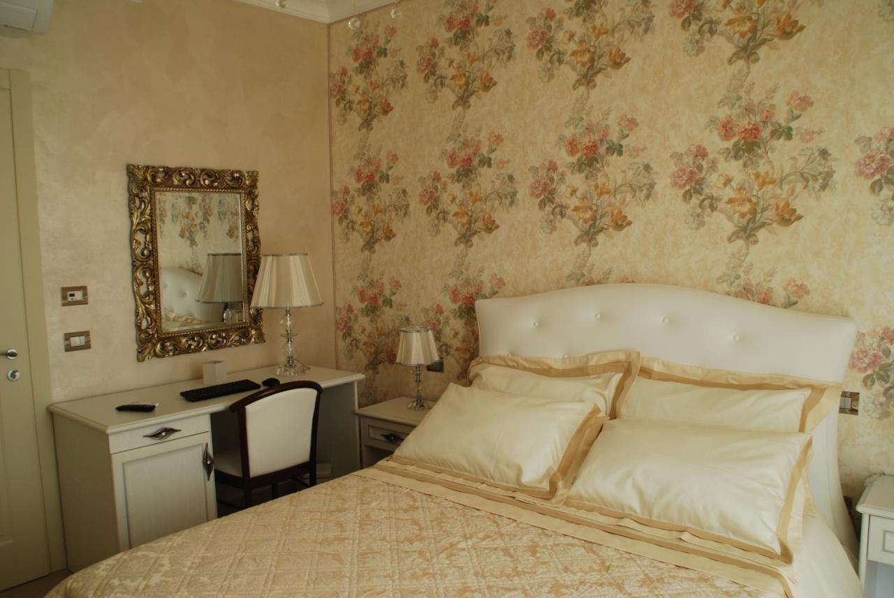 een slaapkamer met een bed, een bureau en een spiegel bij Daphnae House in Palma di Montechiaro