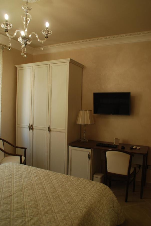 een slaapkamer met een bed, een bureau en een tv bij Daphnae House in Palma di Montechiaro