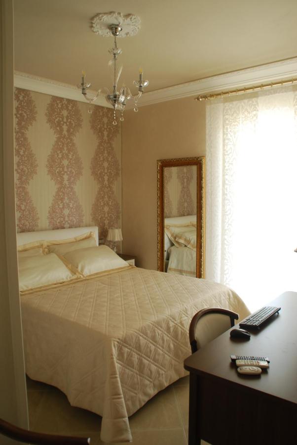 een slaapkamer met een bed, een bureau en een spiegel bij Daphnae House in Palma di Montechiaro