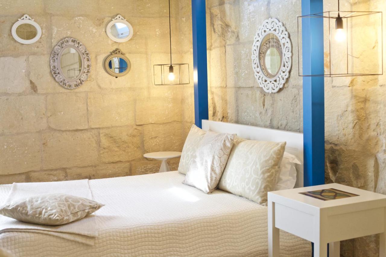 een slaapkamer met een bed met een blauwe paal bij Don Agostino Relais Masseria in Martano