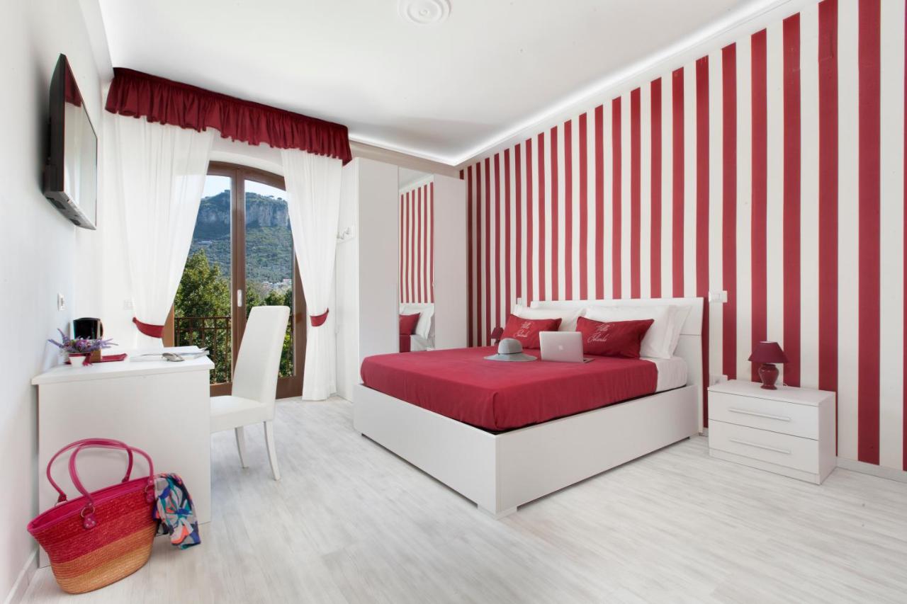 een slaapkamer met een rood-wit gestreepte muur bij Villa Iolanda in Piano di Sorrento