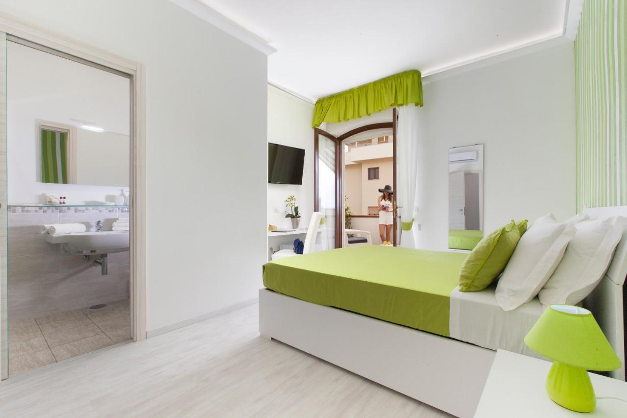 een slaapkamer met een groen-wit bed en een badkamer bij Villa Iolanda in Piano di Sorrento