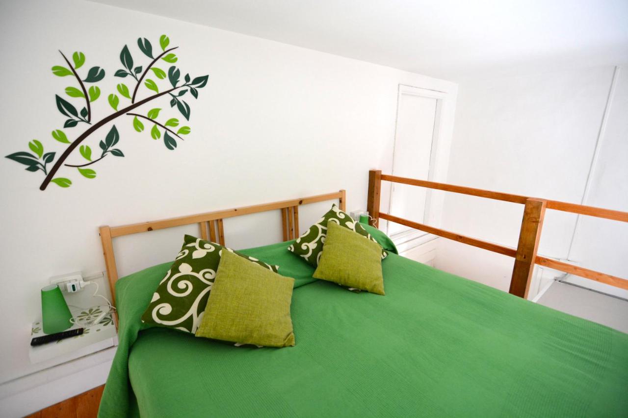 een bed met groene lakens en kussens in een slaapkamer bij B&B Tecla in Napels