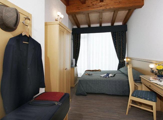 een slaapkamer met twee bedden, een bureau en een raam bij Hotel Mary in Campalto