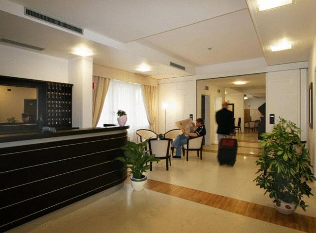 een lobby met mensen die op stoelen zitten in een gebouw bij Hotel Mary in Campalto