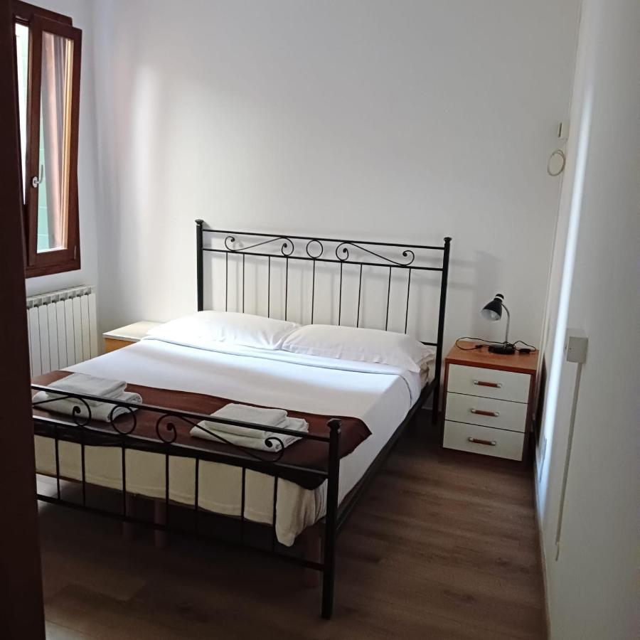 een slaapkamer met een bed en een commode met een lamp bij Casa Aurora in Venetië